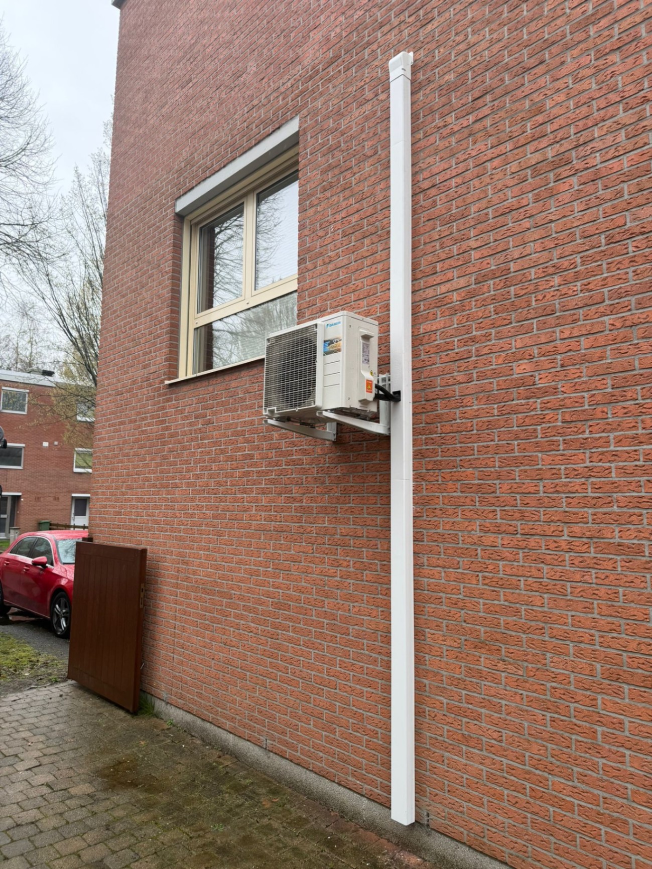 Daikin wandunit met buitenunit op rode gevel - foto 2